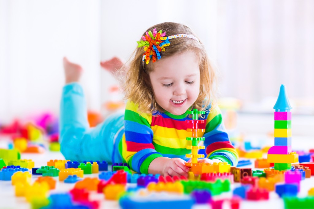 Little girl playing with toy blocks